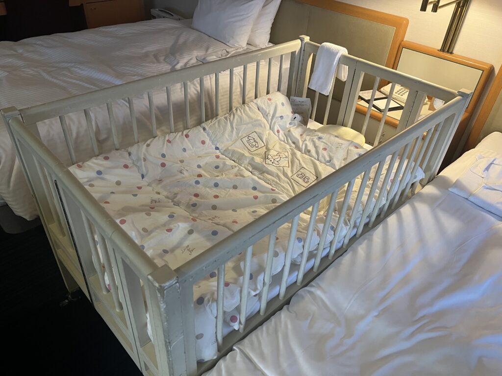 Baby crib set up between two beds at Sapporo Grand Hotel