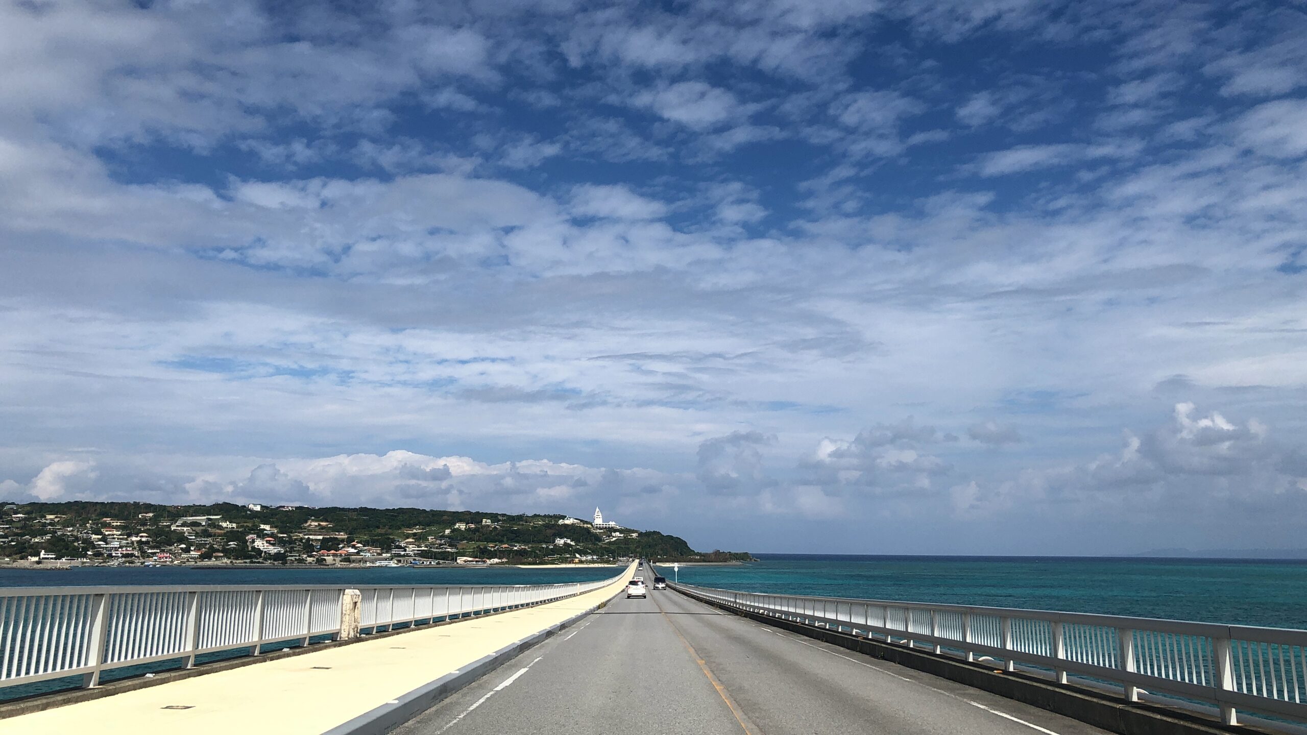 古宇利島へと続く古宇利大橋と青い海に囲まれた道路の風景