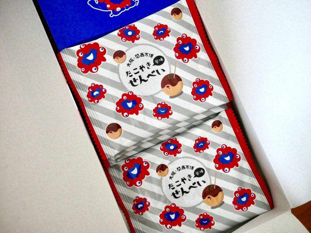 大阪・関西万博2025限定「ミャクミャクたこ焼きせんべい」の中身。ミャクミャクとたこ焼きが描かれた個包装が2段に並んでいる。