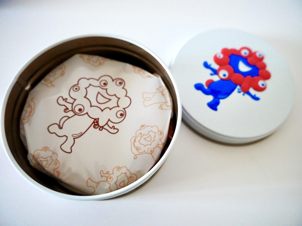 ミャクミャクイラスト入りの個包装。缶によってコーヒーまたはいちごクリーム味。