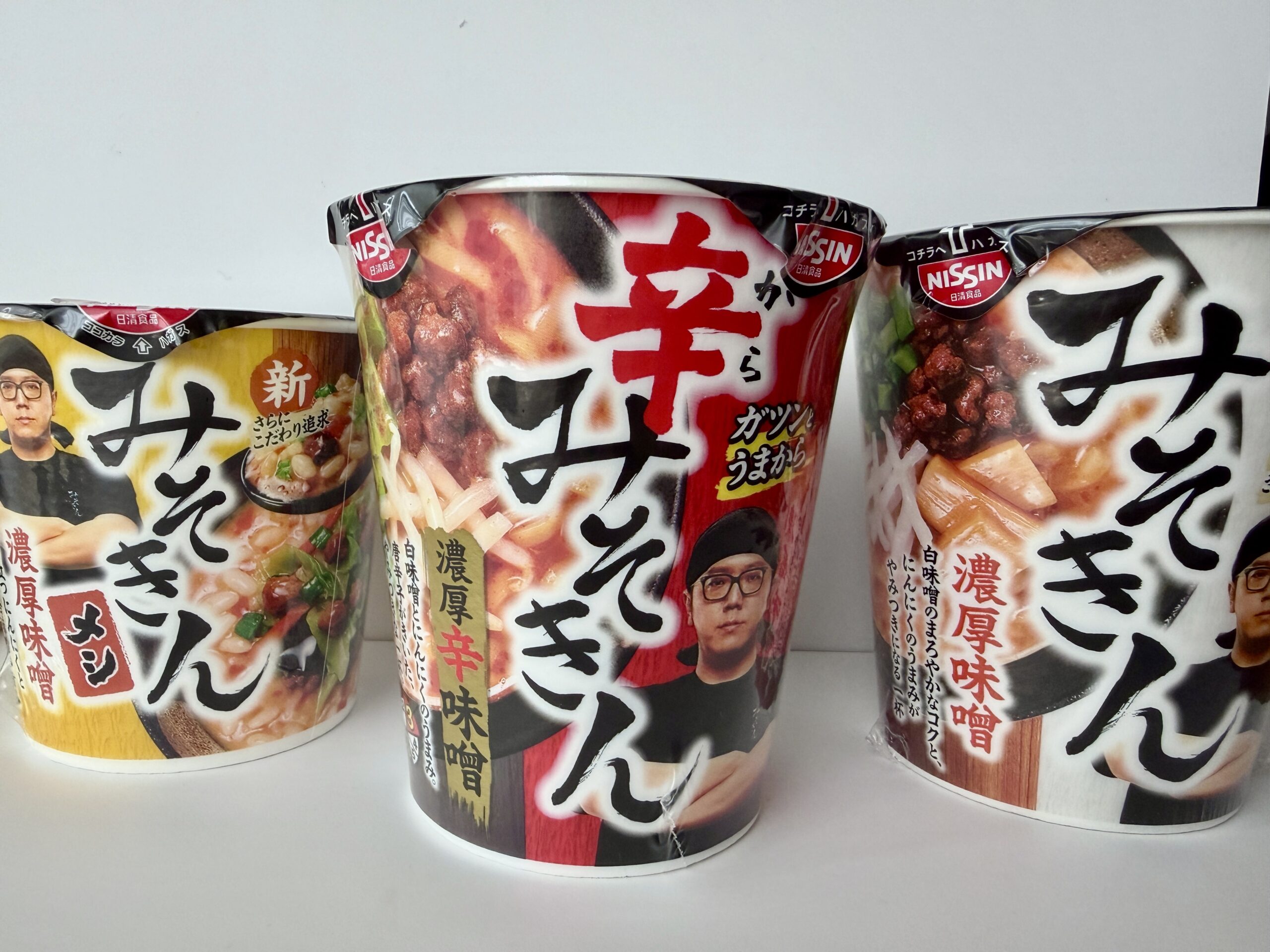 セブンイレブンで発売された日清食品の「みそきん」「辛みそきん」「みそきんメシ」3種類が並ぶカップ麺の写真。新作辛みそきんが中央に配置されている