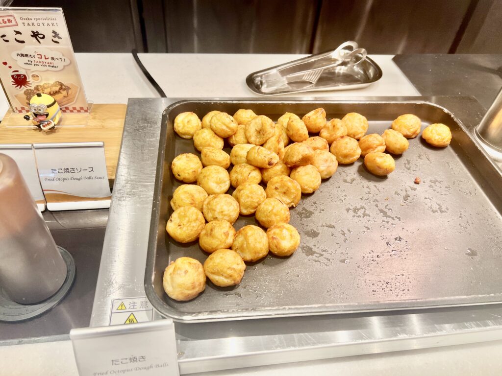 A tray of freshly cooked takoyaki at the breakfast buffet, showcasing Osaka’s iconic dish.