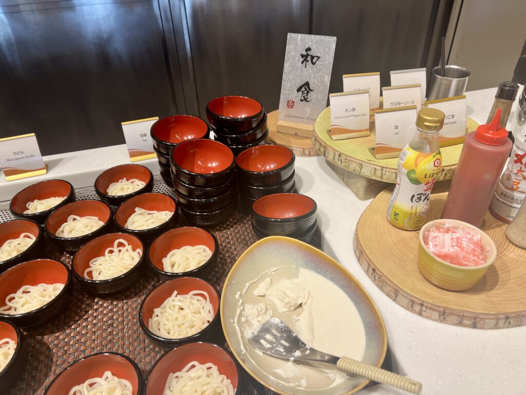 Small bowls of udon noodles and condiments at the Japanese food section of the Universal Port Vita breakfast buffet.