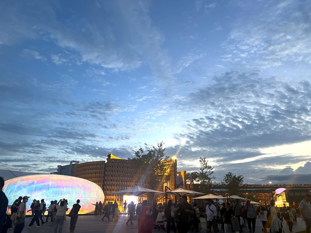 Night scene at Expo 2025 with illuminated domes and crowds