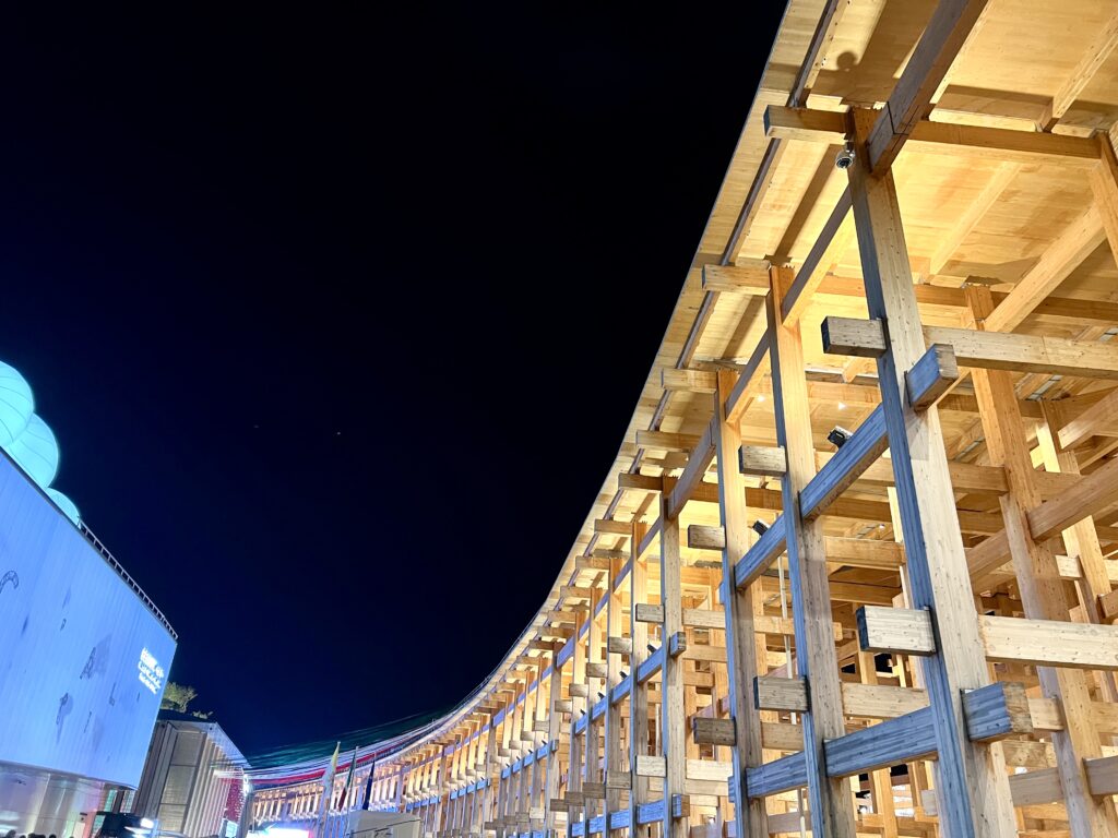 Expo 2025 night view under the large wooden roof structure