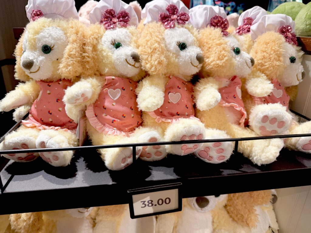 アウラニのショップに並ぶピンクのエプロン姿のクッキー・アンぬいぐるみ