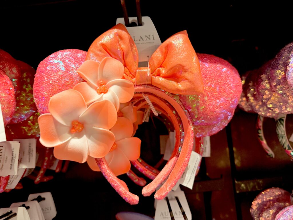 ピンクのスパンコールとオレンジ色の花を飾ったアウラニのカチューシャ